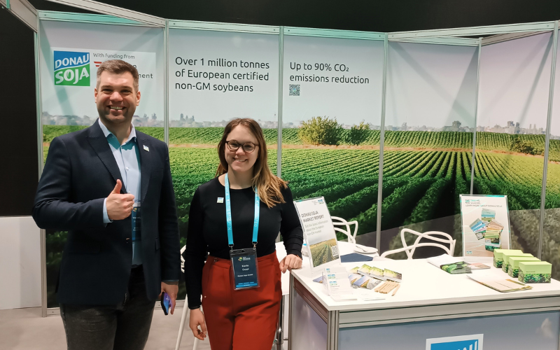 Donau Soja team at trade fair stand highlighting certified non-GM soya, CO₂ reduction, and European sustainability goals.