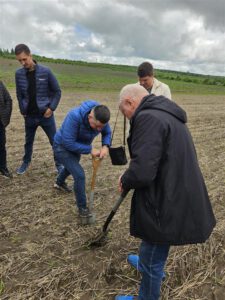 Participants inspect soil conditions during a no-till farming field demonstration in Moldova.