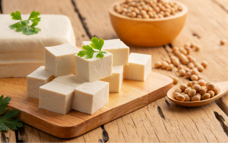 europe-soya-certified-tofu-lower-carbon-footprint-lca-study_webimage Cubed natural tofu on a wooden board with fresh soybeans – produced with Europe Soya certified soybeans, shown to reduce carbon footprint by 30%